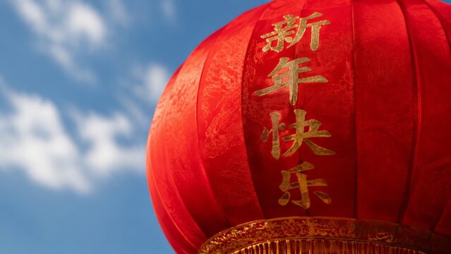 A red chinese lantern bearing the phrase "Happy New Year" (新年快乐) in gold calligraphy hangs against a blue sky with faint white clouds