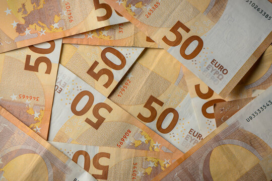 Stack of fifty euro notes arranged beautifully on a flat surface in warm light