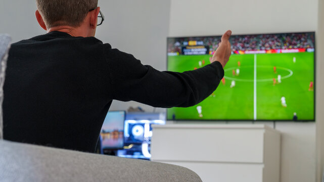 Man reacting to soccer match on television at home
