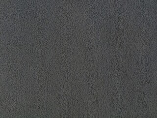 Full frame close-up shot of dark grey soft fleece fabric texture. Ideal for textile material backgrounds, clothing design concepts, and warm winter fashion backdrops © Eka