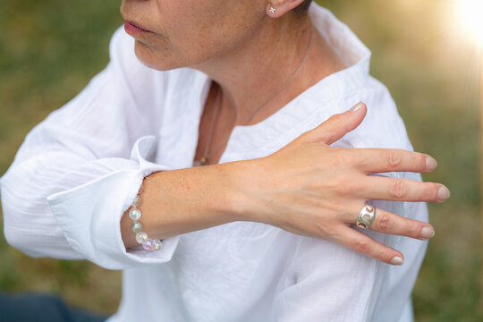 Mindful hand placement near the shoulder during a holistic healing practice that promotes relaxation, restores balance, and supports physical and emotional wellness.