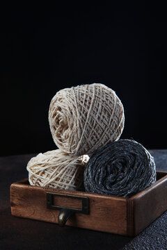Yarn for knitting or crocheting. Wool tweed yarn in balls lies in wooden box. Handmade work. Hobby concept