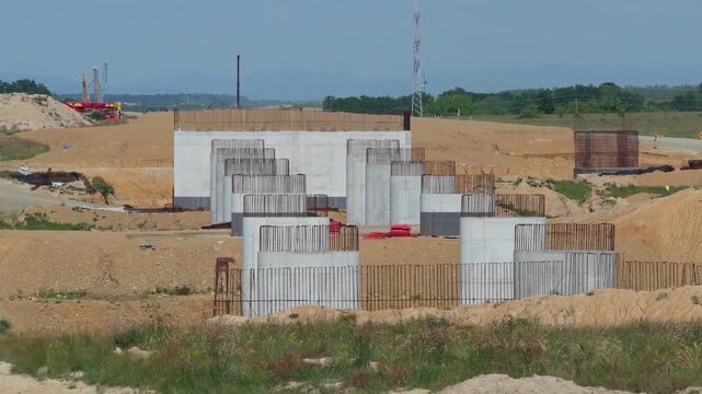 Twin Rows Of Concrete Viaduct Pillars With Exposed Rebar At Highway Construction Site Medium Telephoto Drone Shot, Continued Lateral Aerial Sweep