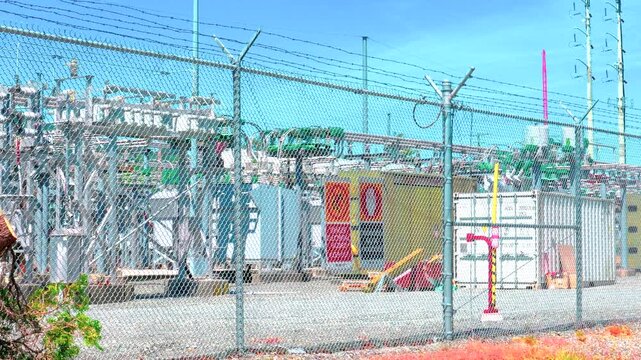 Electrical substation facility behind barbed wire chain link fence
