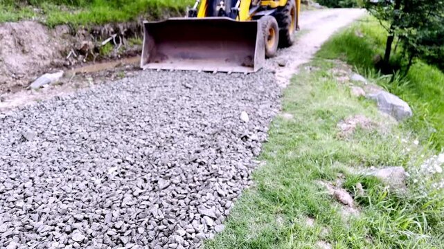 JCB Machine Leveling Gravel on Road Construction Site for Highway Infrastructure Development, Civil Engineering and Earthmoving Equipment Operations Progress