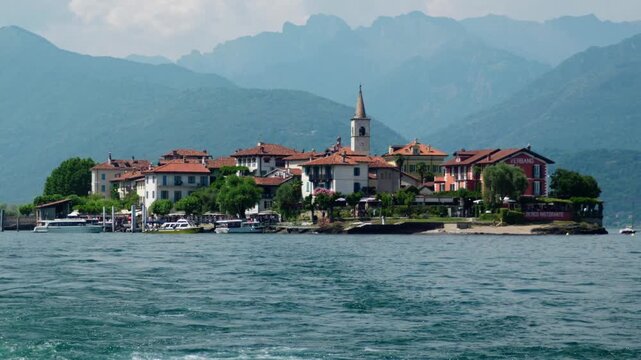 Stunning view of isola dei pescatori, one of the borromean islands on lake maggiore, with its charming village and alpine background