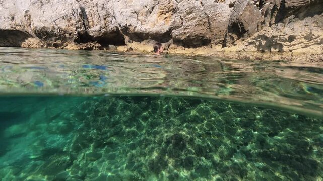 Boy swimming split shot over under half underwater