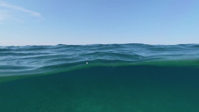 Split shot of sea water over under half underwater view of clear ocean