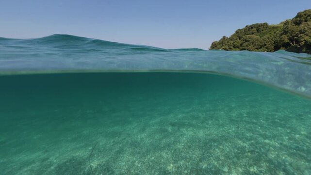 Split level view of turquoise sea water, underwater and sky