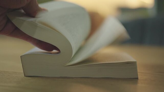 Slow motion of Hand Flipping Book Pages on Wooden Table. Education Study Concept.