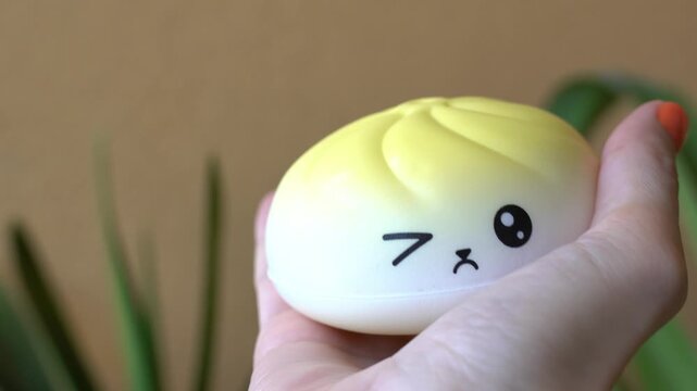 hand holding a trendy dumpling squishy toy. Concept of relaxation, emotional wellness, mindfulness, and anti-stress lifestyle
