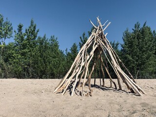 The lodge. Unfinished teepee on the sand, construction technology. © fizke7