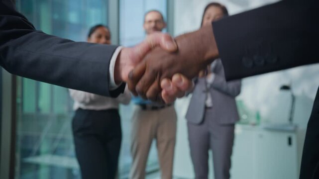 Multiethnic business team shaking hands in office. Two unrecognizable men diversity businessmen shake arms greeting with handshaking three agents happy applauding corporate success partnership deal