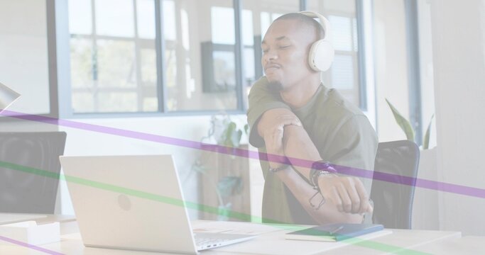 Office worker at laptop glancing wrist checking watch stretching purple or green streaks sweeping de