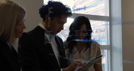 Man in suit by window swiping tablet, projecting holograms and code while team reviewing work data