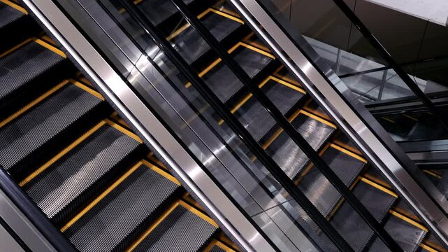 Escalator metal stairs with black and yellow modern indoor architecture featuring moving step handrail safety public transportation building facility urban design technology mechanical structure