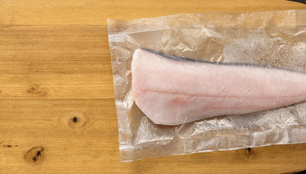 Vacuum Packed Seabream Fillet on Wooden Surface