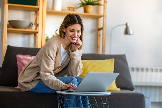 Young female designer, freelancer working in the office. Female using laptop to searching info.