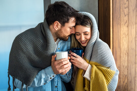 A loving couple shares a quiet winter morning wrapped in warm blankets, finding emotional intimacy