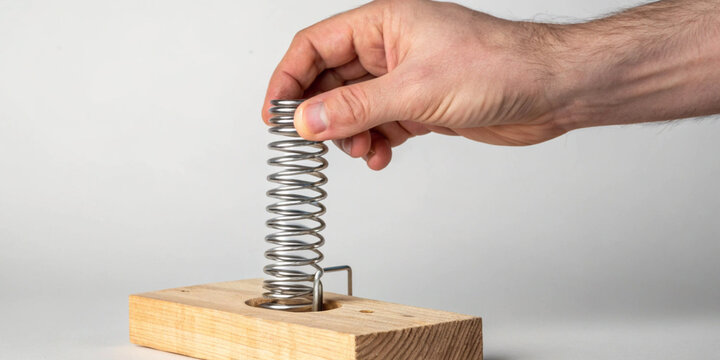 Flexibility and adaptability work under pressure with hands pressing a metal spring