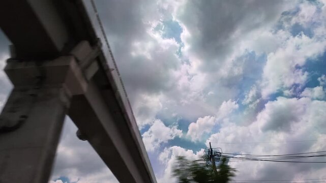 Looking up of widow car Power lines crossing a vibrant cloudy sky rainy season landscape.