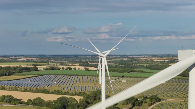 Spinning Wind Turbines and Solar Farm on a Sunny Day