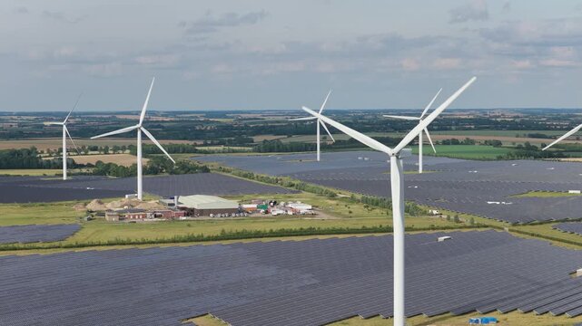 Wind Turbines and Solar Farm Produce Clean Energy on Sunny Day