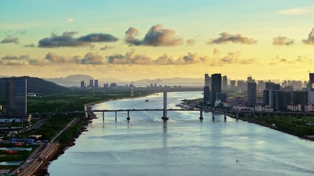 Aerial view of a modern bridge and city skyline at sunset in Zhuhai, China