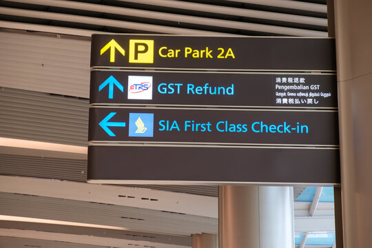 Changi Singapore Airport directional sign showing Car Park 2A, GST Refund, and SIA First Class Check-in with clear visual guidance for travelers