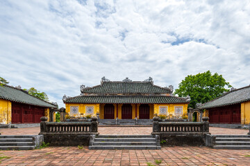 Fototapeta premium Nguyen dynasty palace courtyard with yellow buildings and tiled roof at Hue Imperial Citadel, Vietnam