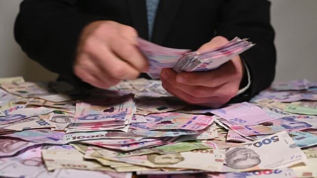 Hands holding pile of colorful Ukrainian banknotes, economic power and monetary success in financial sphere. close-up view of businessman with money. prosperity, investment, cash growth. concept bribe