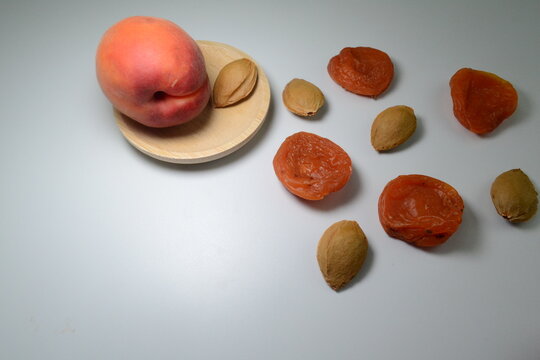 Fresh ripe apricot served with dried apricots and natural kernels isolated on white background. Healthy snack and organic fruit concept with generous copy space for food design.