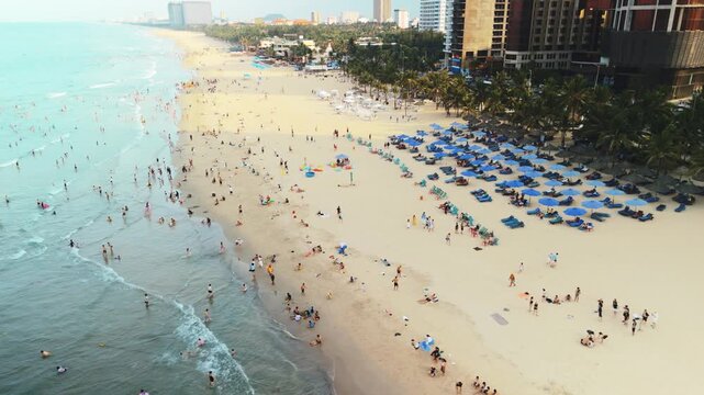 My khe beach in danang, vietnam sees numerous people on holiday, enjoying the warm tropical weather and clear waters, with beachfront resorts lining the extensive coastline