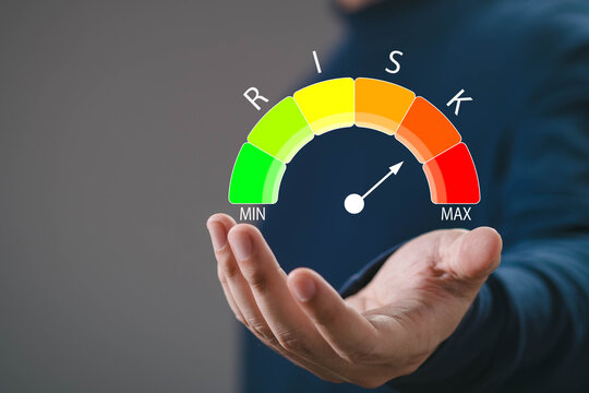 Risk management gauge with hand holding digital scale indicator, representing business assessment, performance measurement, financial risk analysis, evaluation strategy, decision making optimization.