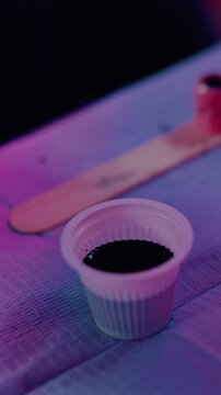 Tattoo, parlor and hands of person with ink cap to prepare for artwork, design and body modification. Shop, liquid and artist with machine, pigment and tools for permanent art, service and start