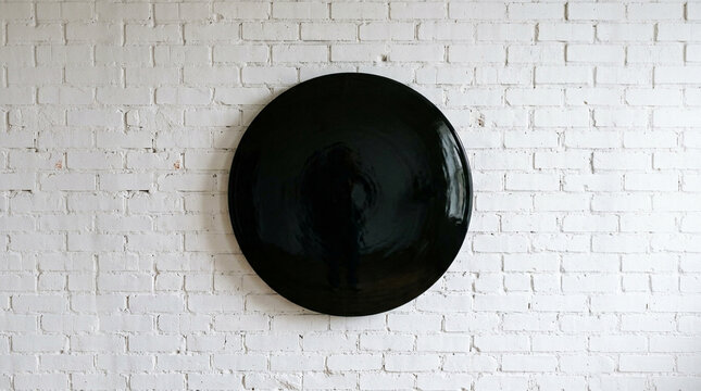 Large Glossy Black Round Mirror on White Brick Wall Interior