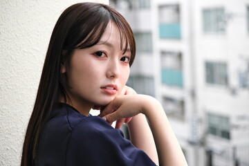 Fototapeta premium ベランダから見える景色を眺めて休憩する女性
