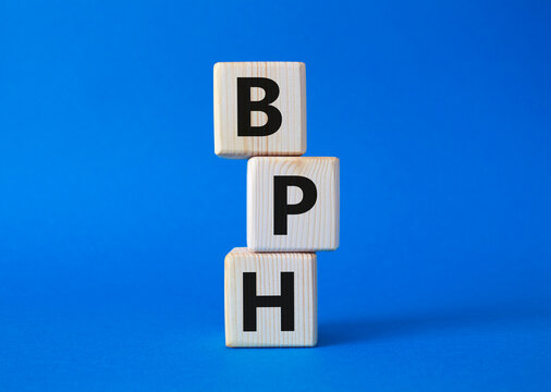 BPH - Benign Prostatic Hyperplasia symbol. Wooden cubes with word BPH. Beautiful blue background. Medical and BPH concept. Copy space.