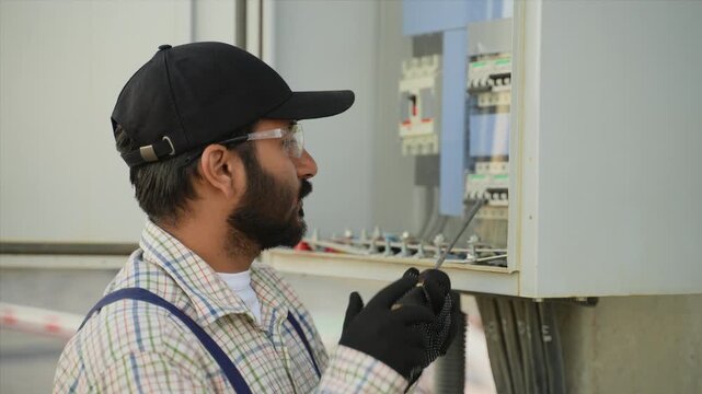 Indian electrician technician maintaining electrical fuse box panel