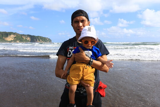 June 15 2019 Yogyakarta Indonesia Man Holding Young Child Standing on Wet Sand Mirror Reflection at Parangtritis Beach
