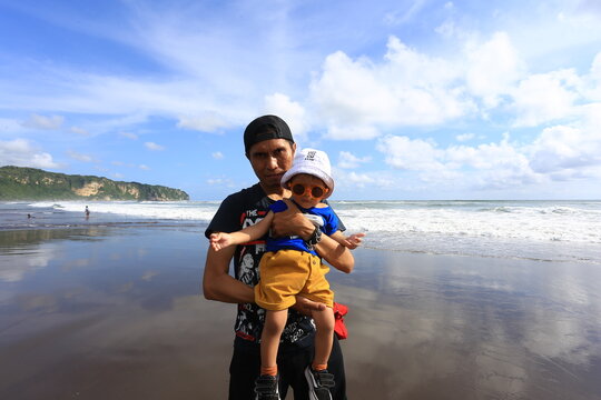 June 15 2019 Yogyakarta Indonesia Man Holding Young Child Standing on Wet Sand Mirror Reflection at Parangtritis Beach