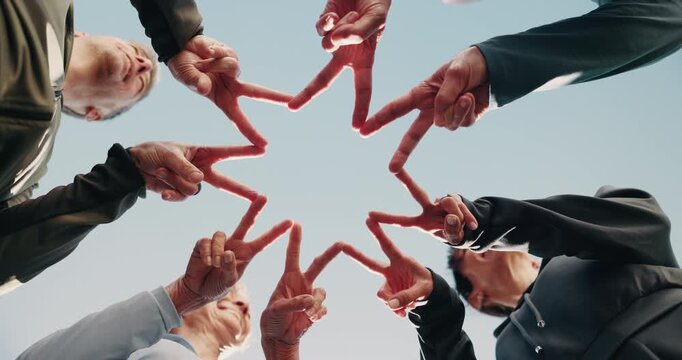 People, teamwork or hands together with star shape for fitness or outdoor mission below blue sky. Low angle, happy or active group with symbol, peace sign or synergy in circle for community wellness