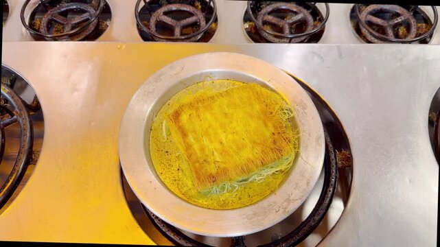 Cooking Process &ndash; Frying Traditional Turkish Kadayıf Pastry in a Large Skillet on a Stove Top.Frying Kadayıf on the Stove &ndash; Turkish Dessert Preparation