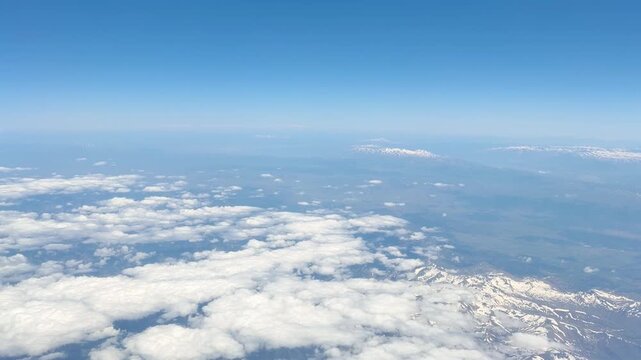 View of White Clouds from an Airplane Window During a Flight at High Altitude
