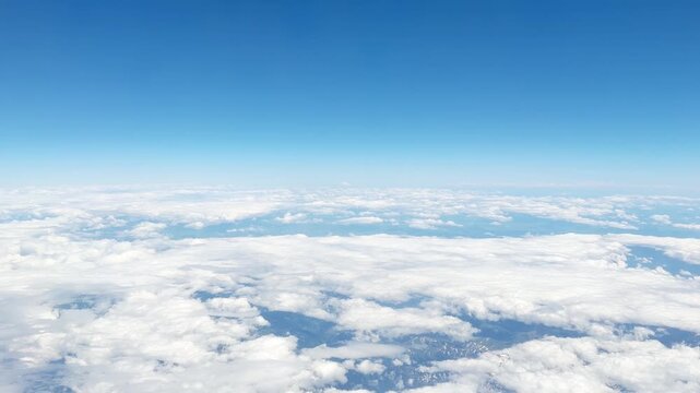 View of White Clouds from an Airplane Window During a Flight at High Altitude