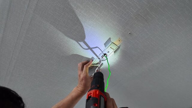 Person changing kitchen ceiling bulb. 
