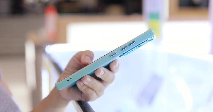 Hands using and holding a smartphone in an mobile phone store, Technology, mobile device, electronics store, retail shopping, consumer electronics, and digital lifestyle concept, close-up