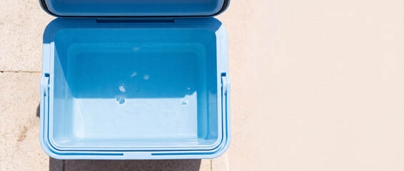 Obraz premium Empty blue cooler box open on hot day, keeping drinks cold, ready for picnic, beach, or travel