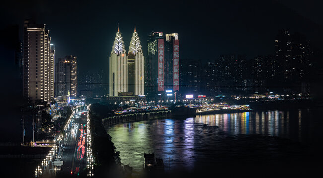 Chongqing, China - 10 Jun 2026 - The Sheraton Chongqing Hotel's distinct, brightly lit golden towers serve as the brilliant centerpiece of the skyline, contrasting sharply against the dark night. The 