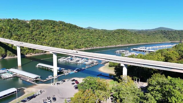 Aerial View of Sunset Marina & Resort and Highway 111 Bridge on Dale Hollow Lake, Monroe, Tennessee - Scenic Waterfront with Boat Slips, Forested Shoreline, and Clear Blue Water
